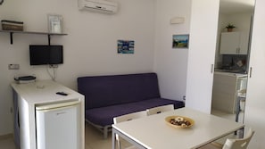 Uma cozinha compacta equipada com geladeira, micro-ondas e pia.