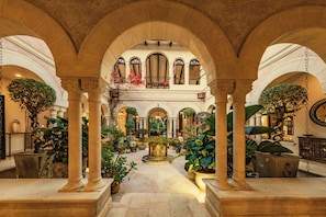 A spacious courtyard with arches, potted plants, and a central fountain. - Room-villa Firenze, Costa Rica All Inclu (Jacó)