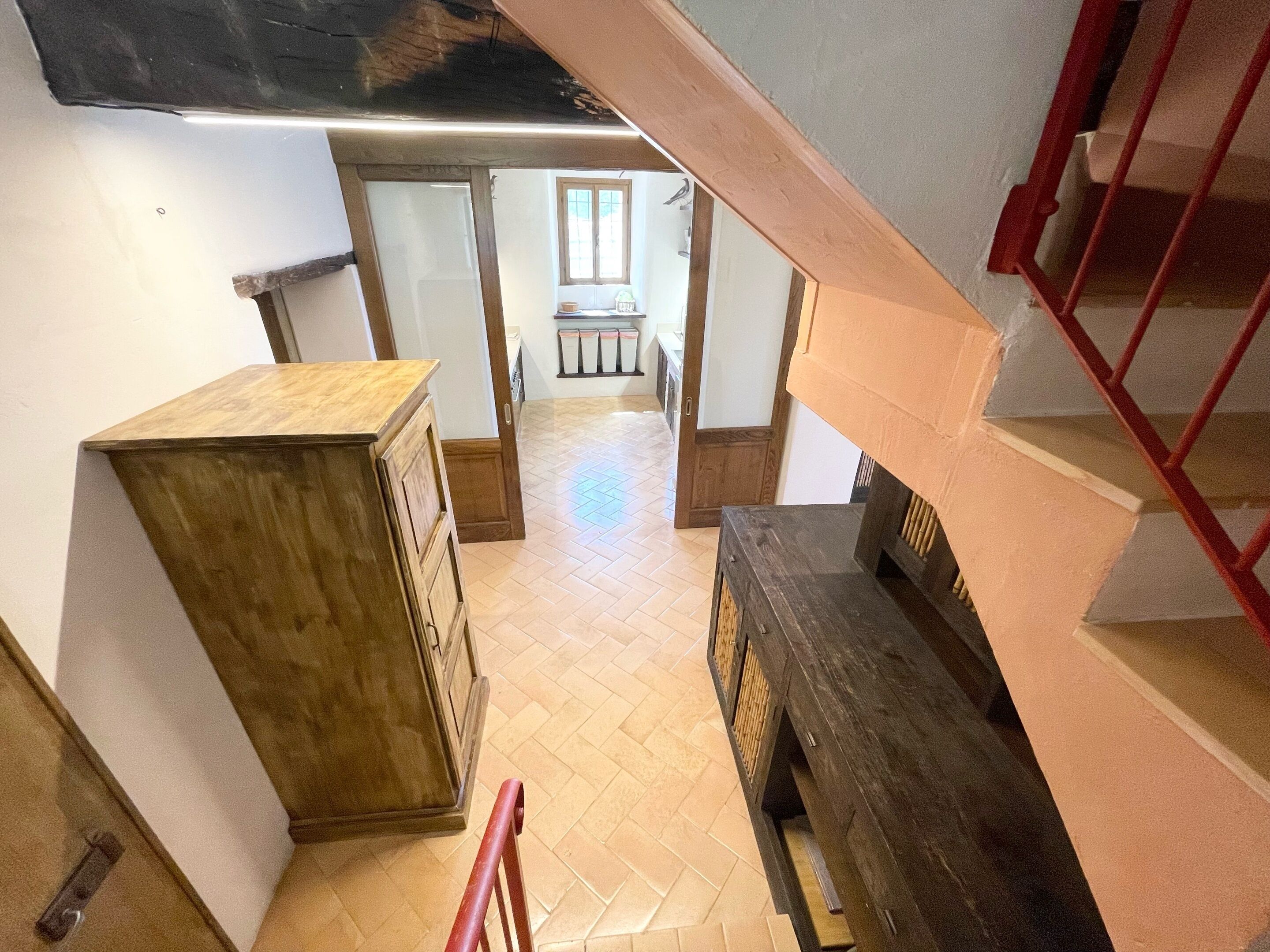 A staircase with wooden steps and a red railing.