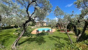 A swimming pool surrounded by trees and a well-maintained lawn. - Spoleto Tranquilita Sleeps 20 With Wifi Pool Yoga Studio Gardens and Views (Spoleto)