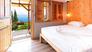 A bedroom with a wooden bed, a view of the sea, and a balcony with wooden railings. - Castle Boutique Hotel Alanya (Alanya)