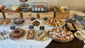 A buffet table with various food items and labels.