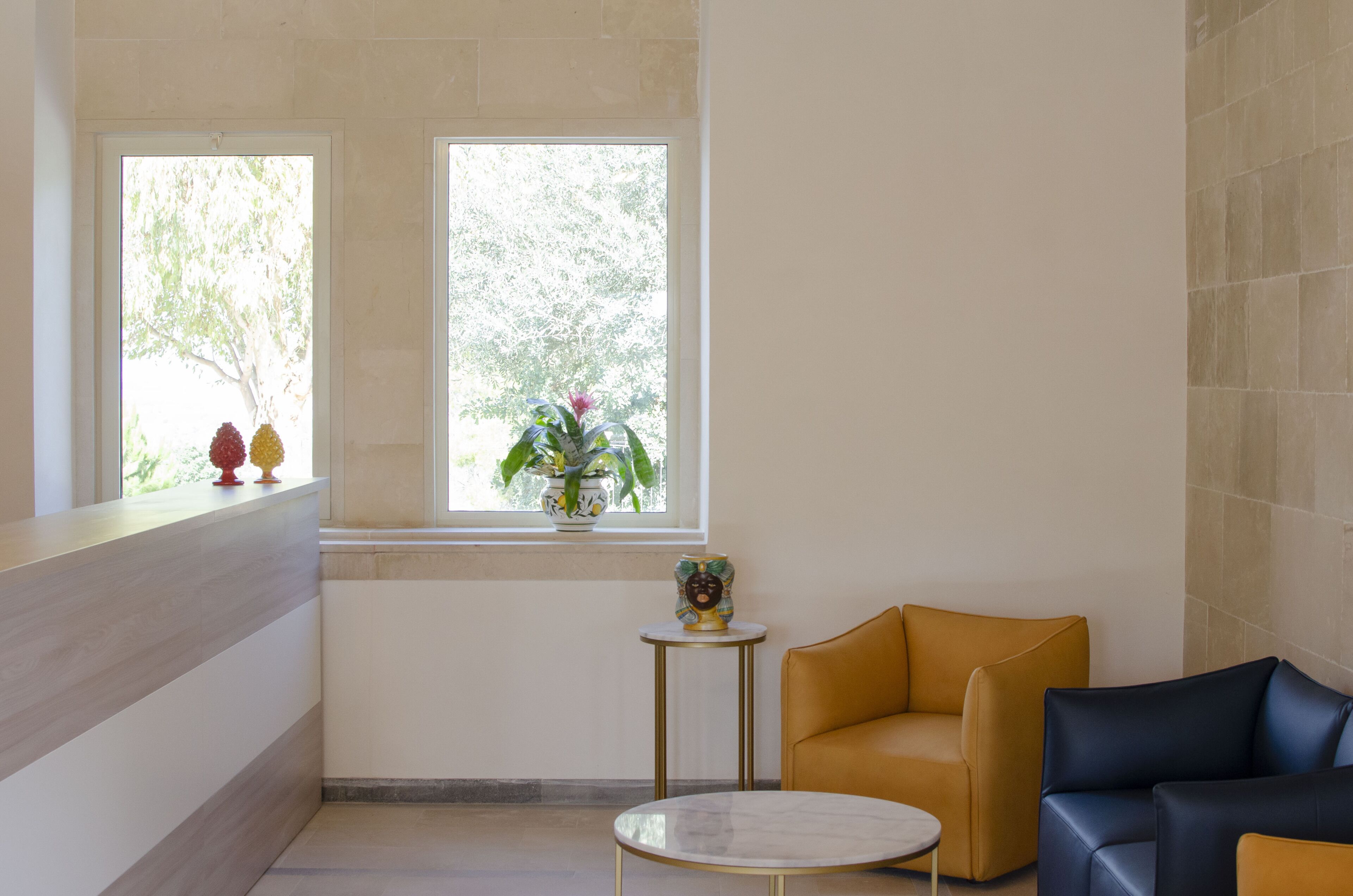 Un intérieur moderne comprenant un coin salon, une petite table et une fenêtre donnant sur la verdure.