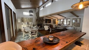 Un vaste espace de vie doté d’une cheminée, d’une table à manger et de sièges confortables.