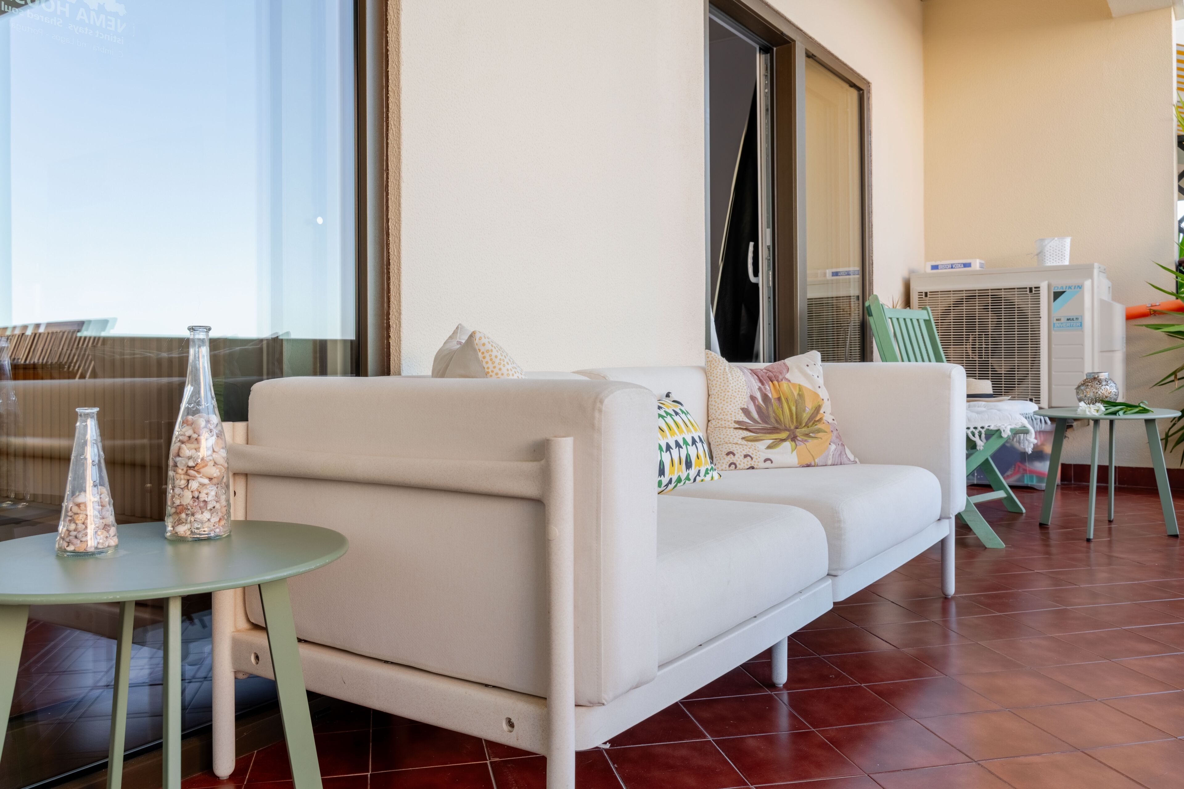 A modern living room with a sofa, a small round table, and decorative glass bottles.