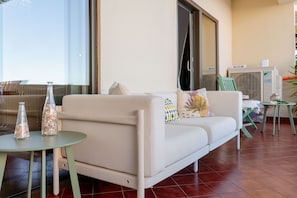 A modern living room with a sofa, a small round table, and decorative glass bottles. - Ocean View • Walk to Beach • Pool • Lagos • 64 (Lagos)