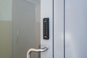 Un panneau de commande d’ascenseur moderne, doté d’un clavier numérique et d’un bouton d’alimentation vert.