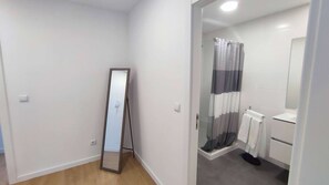 A bathroom with a shower, a toilet, and a mirror. - Atlantic Valley - Furnas (Furnas)