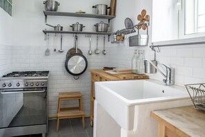 Réfrigérateur, un four, bouilloire électrique, vaisselle et ustensiles