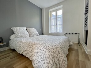 A bedroom with a bed, a window, and a radiator.