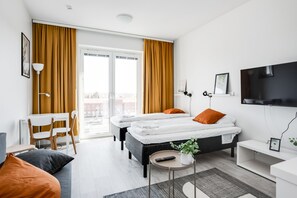 A modern hotel room with a large bed, two bedside tables, a desk, and a TV. - Hiisi Homes Nokia (Nokia)
