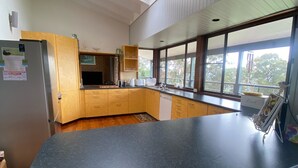 A modern kitchen with a black countertop, wooden cabinets, and a built-in oven. - Idyllic Family Getaway on a farm  - Blue Mountain (Bowen Mountain)