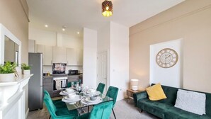Um apartamento moderno com área de jantar, cozinha e sala de estar.