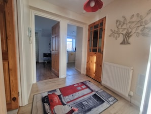 A hallway with wooden doors, a radiator, and a patterned rug. - Lovely 2 Bedroom Apartment With Private Parking (Aberdeen)