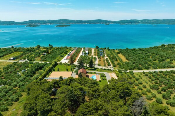 An aerial view of a coastal property with a swimming pool, organized garden areas, and a view of the sea. - Villa Primorje (Sveti Filip i Jakov)
