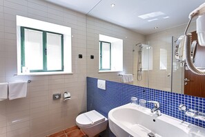 A modern bathroom with a toilet, sink, and shower. There are windows with blinds, a mirror, and a towel rack. - Villa Primorje (Sveti Filip i Jakov)