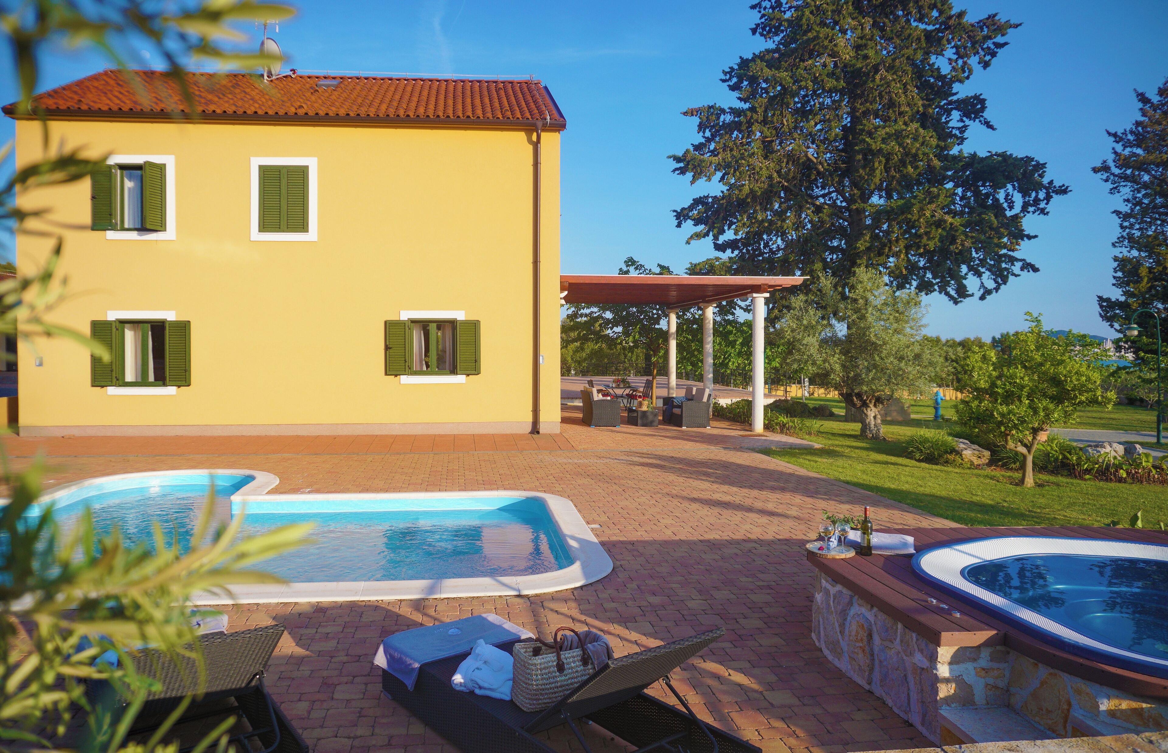 A yellow building with a swimming pool and a hot tub.