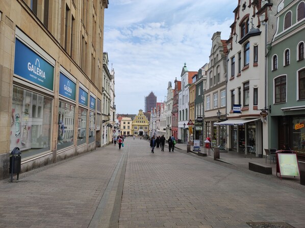 A cobblestone street lined with historic buildings, some with storefronts and signage. - Stunning two-story apartment (Wismar)