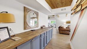 A modern kitchen with a wooden countertop, blue cabinets, and a large mirror. There is a framed welcome sign and a notebook on the counter. - No steps, Game Room, Canoe & Kayaks, Dock, All Paved Roads! 10 min to 2 marinas! (Jasper)