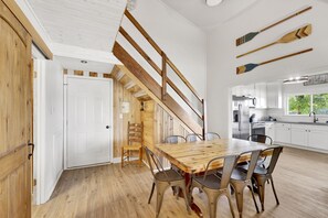Enjoy meals at the dining table in this kitchen, which offers a view of the outdoors through the window.