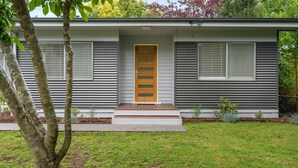 A single-story house with a front door, two windows, and a small porch. - Alpine View Cottage - Close to town (Bright)