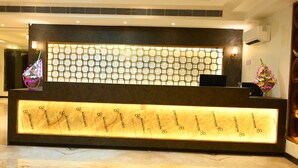 Una reception dal design moderno, con una parete a motivi geometrici e una targhetta luminosa.