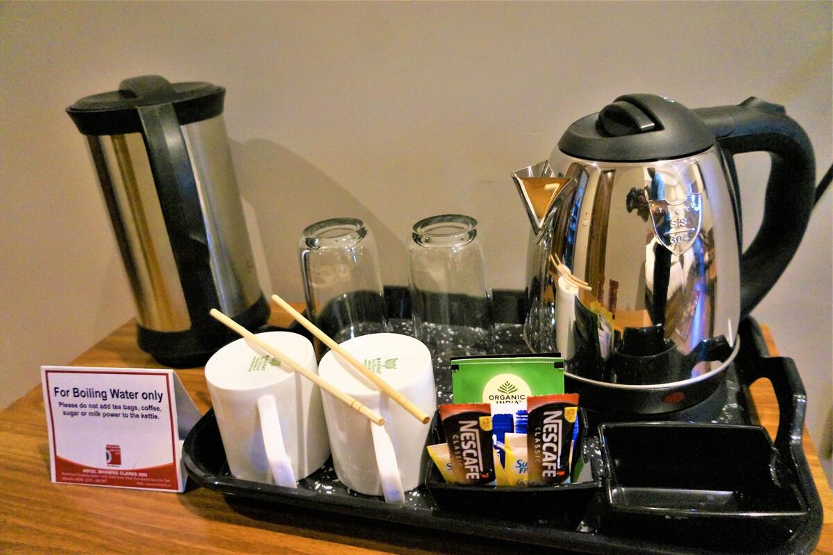 Estación de té con pavas, tazas y sobres de café instantáneo Nescafé.
