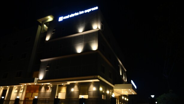 Un hotel dal design moderno, con un cartello ben visibile in alto e numerose finestre illuminate.