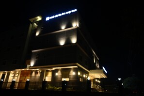 A hotel with a modern design, featuring a prominent sign at the top and multiple illuminated windows. - Neel Clarks Inn Express Agra (Agra)