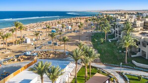 Una località balneare con accesso diretto alla spiaggia, palme e vista sull'oceano.