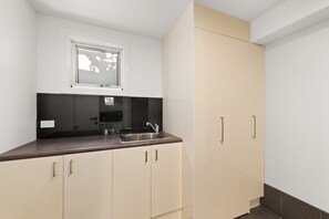 A kitchen with a window, a sink, cabinets, and a countertop.