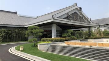 A building with a traditional architectural style, featuring a prominent entrance with steps leading up to a covered area.