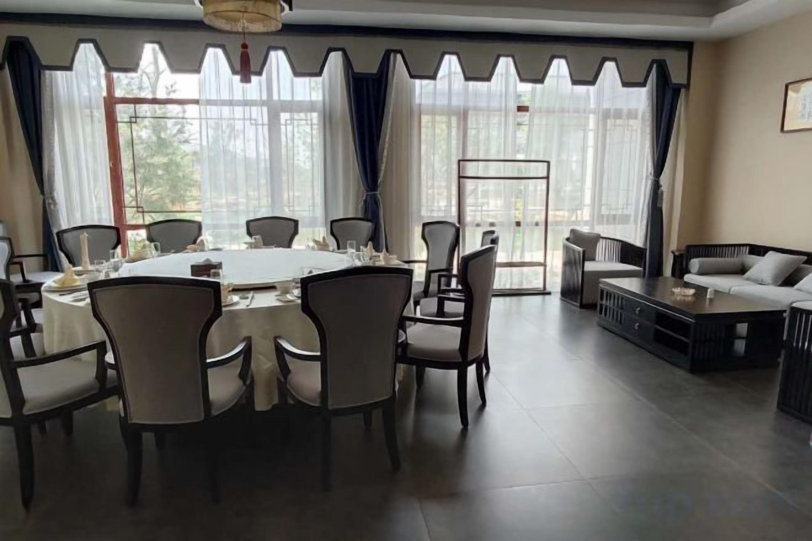 A dining area with a round table surrounded by chairs, a sofa, and a coffee table.