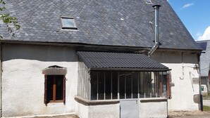 Un bâtiment doté d’un toit en pente, d’une petite fenêtre et d’une porte.