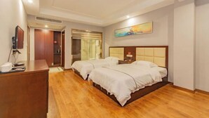 Een hotelkamer met twee bedden, een bureau en een schilderij aan de muur.