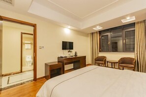Ein Hotelzimmer mit Bett, Schreibtisch, Fernseher und Sitzecke.