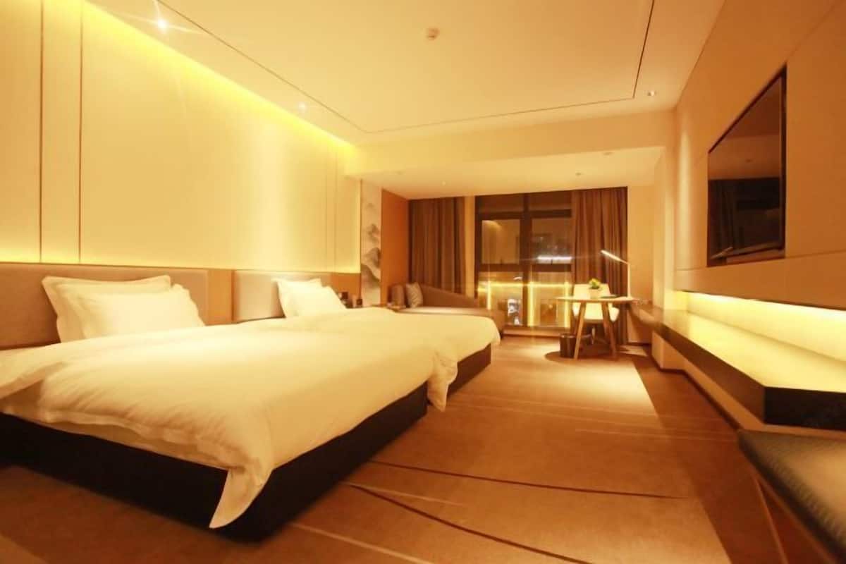 Ein Hotelzimmer mit einem großen Bett, einem Schreibtisch und einer Sitzecke.