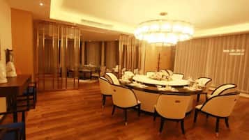 A dining area with a round table, chairs, and a chandelier.