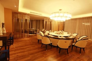 Un comedor con una mesa redonda, sillas y un candelabro.