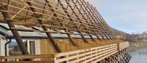 A wooden structure extending over water, likely a part of a building or dock.