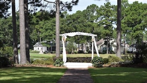 A gazebo in a well-maintained garden with a brick pathway leading to it. - Brunswick Plantation Resort and Golf Studio 1404l Villas in the Heart of NC Seafood Country by Redawning (Calabash)