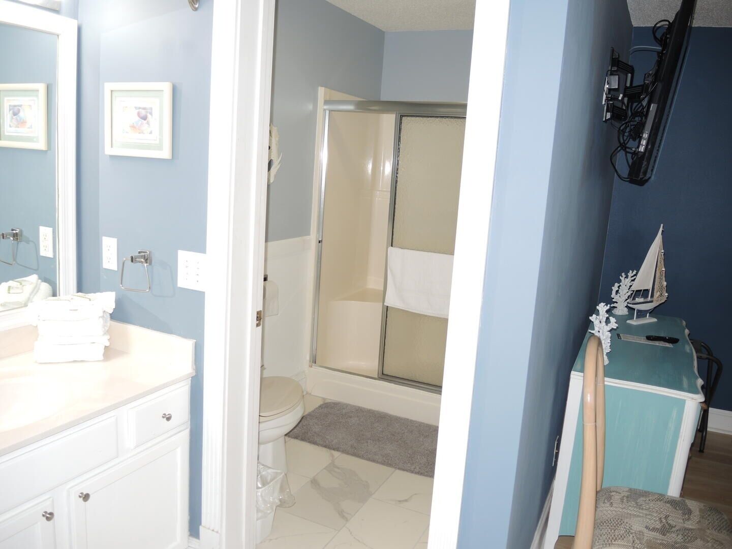 Une salle de bain avec des toilettes, un lavabo et une douche.