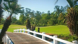 A wooden bridge with white railings leading to a golf course. - Brunswick Plantation Resort and Golf Villa 2705L in the Heart of NC Seafood Country by RedAwning (Calabash)