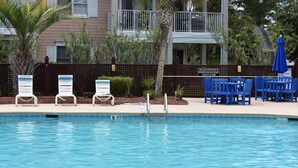 Una piscina con sillas de descanso y un letrero que indica una profundidad de 0.9 metros.