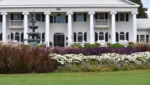 A large white building with columns, a fountain, and a number 380 sign. - 2609l Home by RedAwning (Calabash)