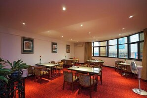 A hotel room with a dining area, large windows, and a red carpet. - Jinlong Hotel (Dongguan)