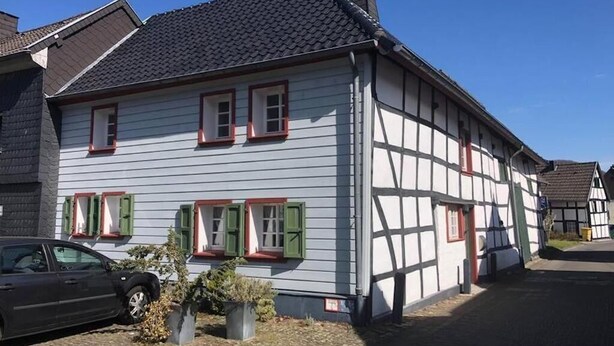 A traditional half-timbered house with a car parked in front. - The small Villa OLEFant in the historic center of Schleiden Olef (Schleiden)