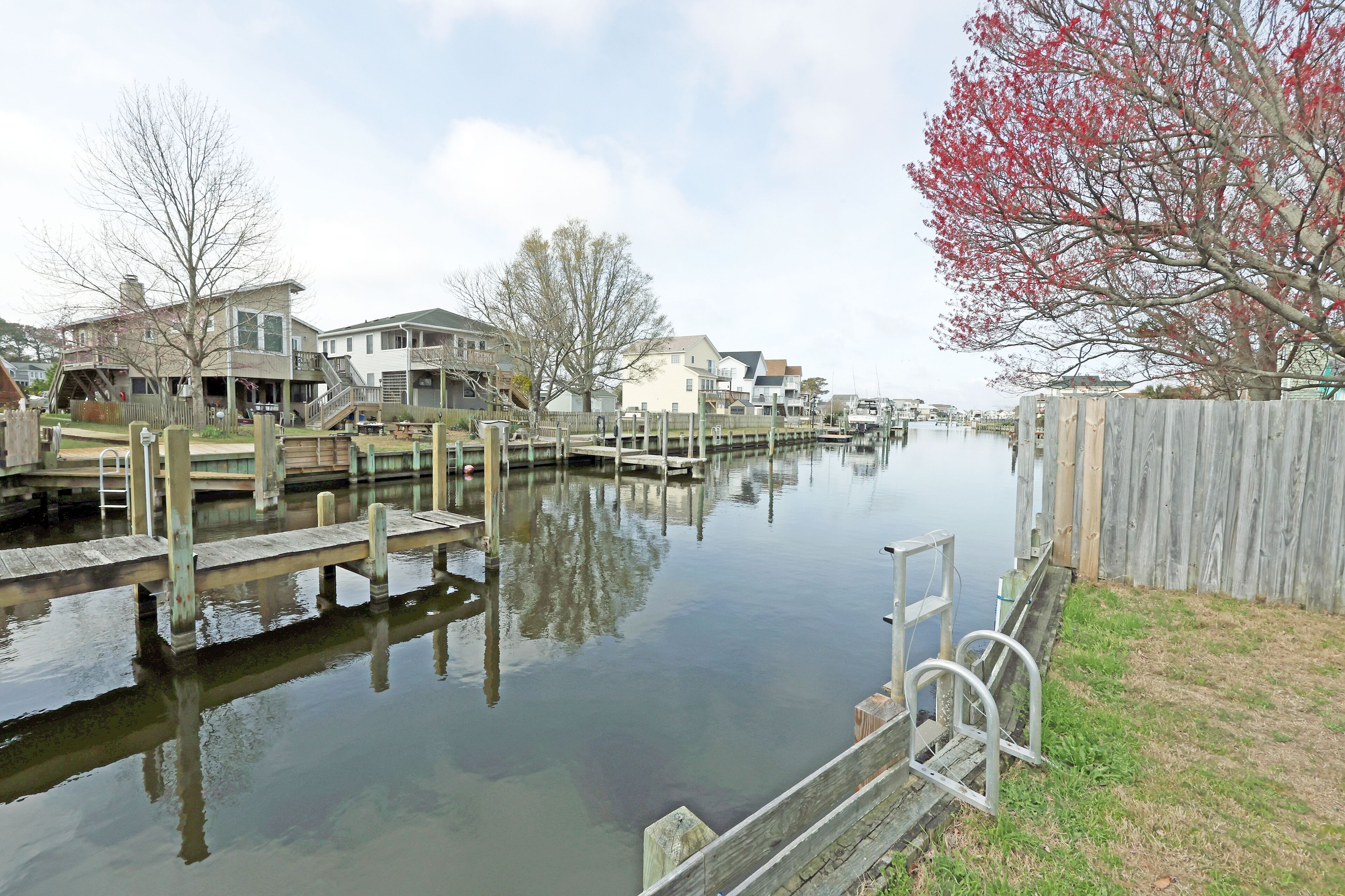 A calm waterway with docks and houses along the shore.
