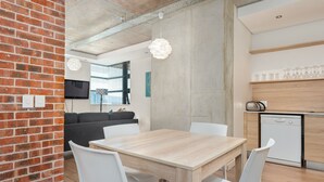 Una cocina moderna con encimera de madera, sillas blancas y lavavajillas integrado.