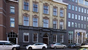 Un edificio histórico con fachada clásica, varias ventanas y un cartel que indica que es el Hotel Dutch Golden.
